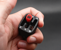 Black gear shifter fidget with a red knob